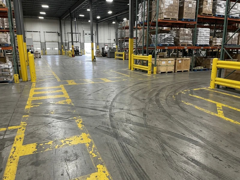 Warehouse line painting Toronto before: worn forklift lanes in Scarborough